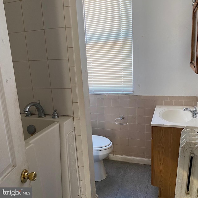 bathroom featuring tile flooring, tile walls, toilet, vanity, and a bath