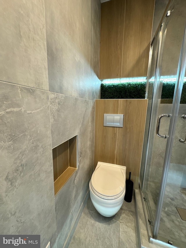 bathroom featuring tile walls, toilet, tile floors, and an enclosed shower