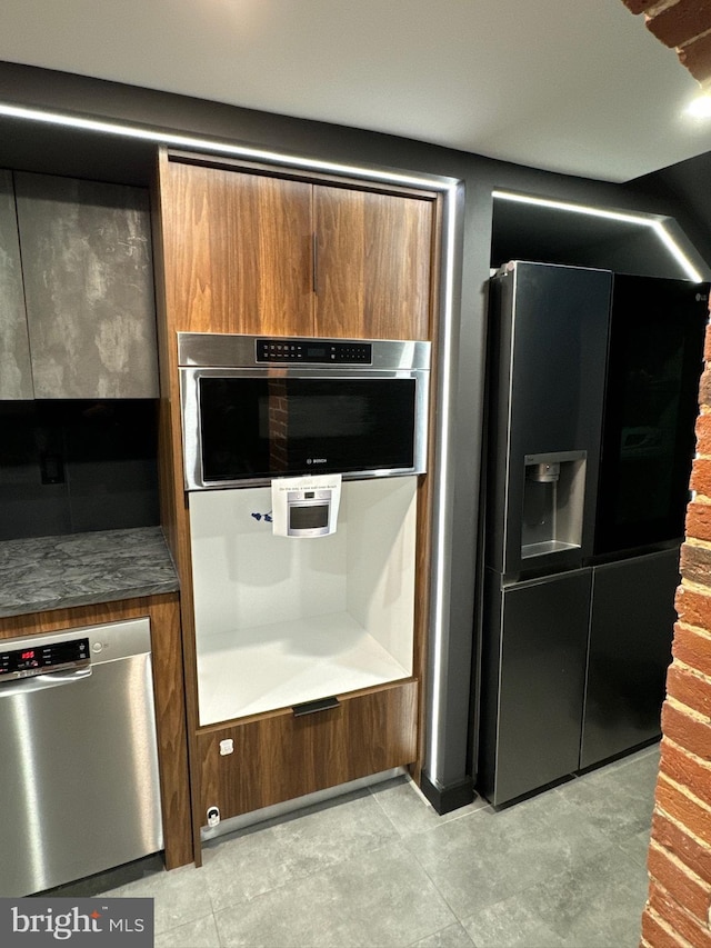 kitchen featuring light tile flooring and stainless steel appliances