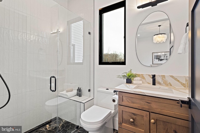 bathroom featuring backsplash, vanity, an enclosed shower, and toilet