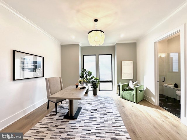 dining space with a chandelier, light hardwood / wood-style floors, and ornamental molding