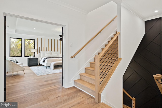 staircase featuring hardwood / wood-style floors and ornamental molding