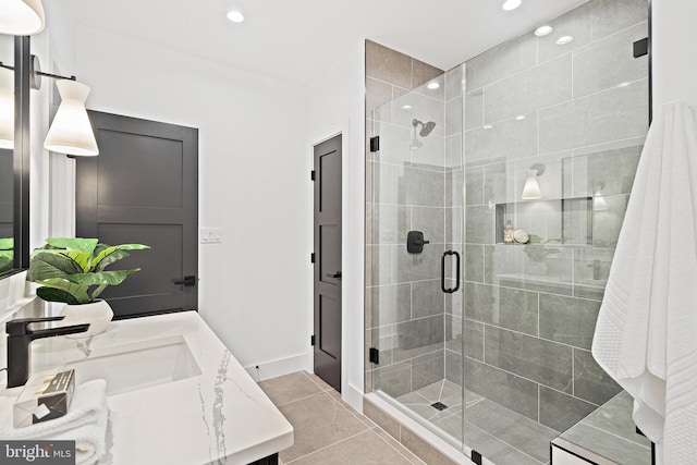 bathroom with tile patterned flooring, vanity, and walk in shower