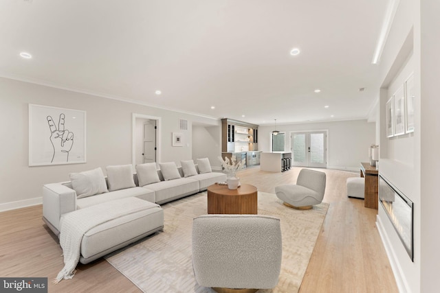 living room with light hardwood / wood-style floors and ornamental molding