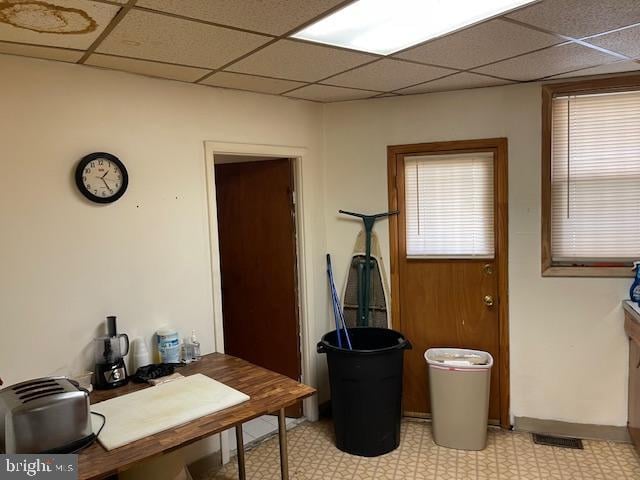 home office with a drop ceiling and light tile floors