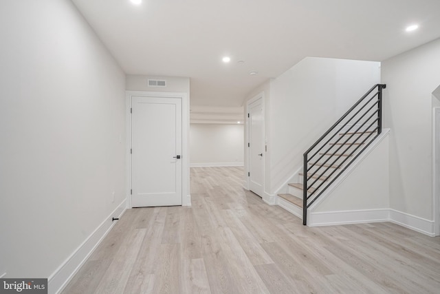 hallway with light hardwood / wood-style floors