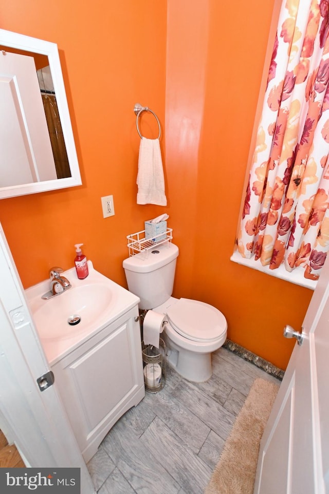 bathroom featuring tile flooring, toilet, and vanity