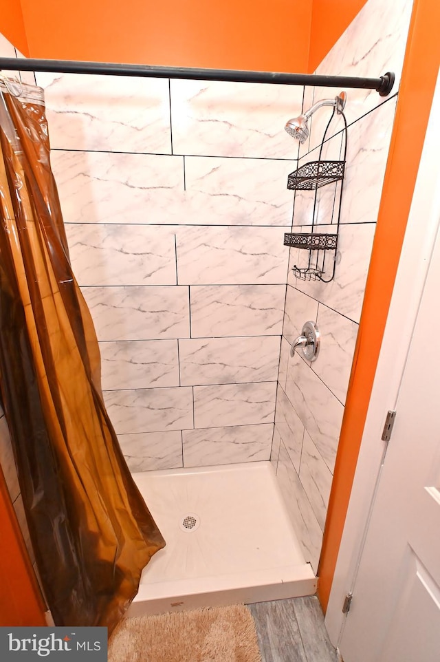 bathroom with hardwood / wood-style floors and a shower with curtain