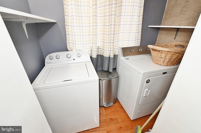 clothes washing area with light hardwood / wood-style flooring and washing machine and dryer