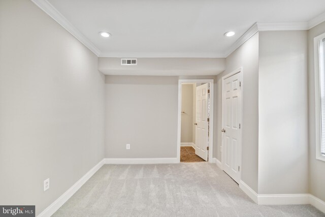 unfurnished room featuring light carpet and ornamental molding