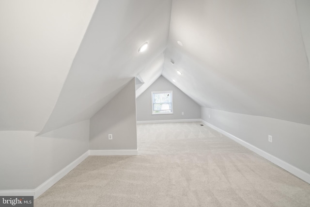 bonus room featuring lofted ceiling and light carpet