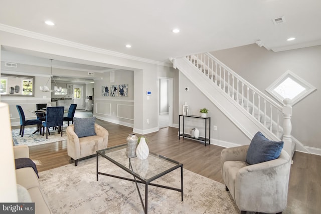 living room featuring wood-type flooring and crown molding