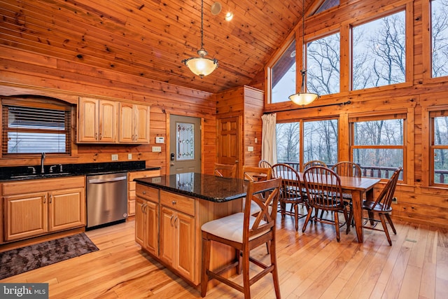 kitchen featuring stainless steel dishwasher, pendant lighting, a kitchen island, sink, and high vaulted ceiling