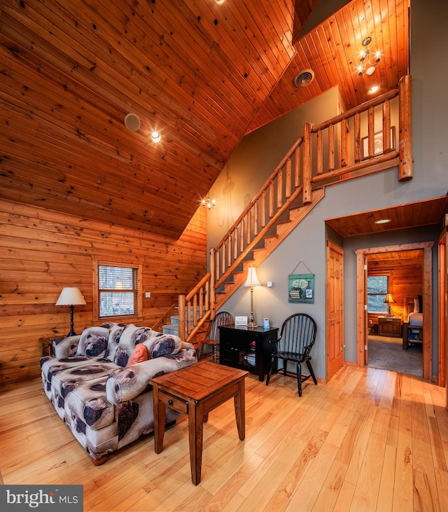 interior space with high vaulted ceiling, light hardwood / wood-style floors, wooden ceiling, and wood walls