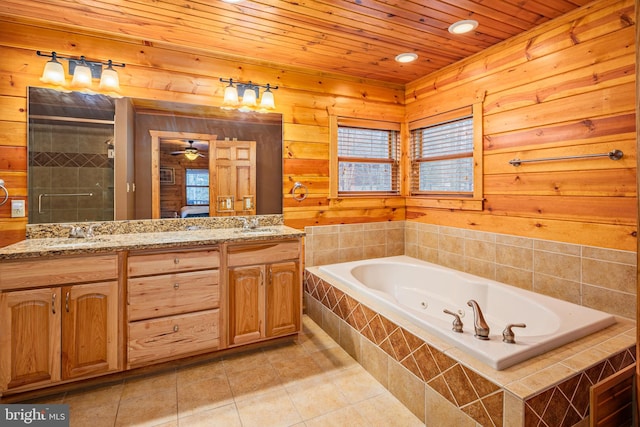 bathroom featuring ceiling fan, wood walls, tile floors, and vanity with extensive cabinet space