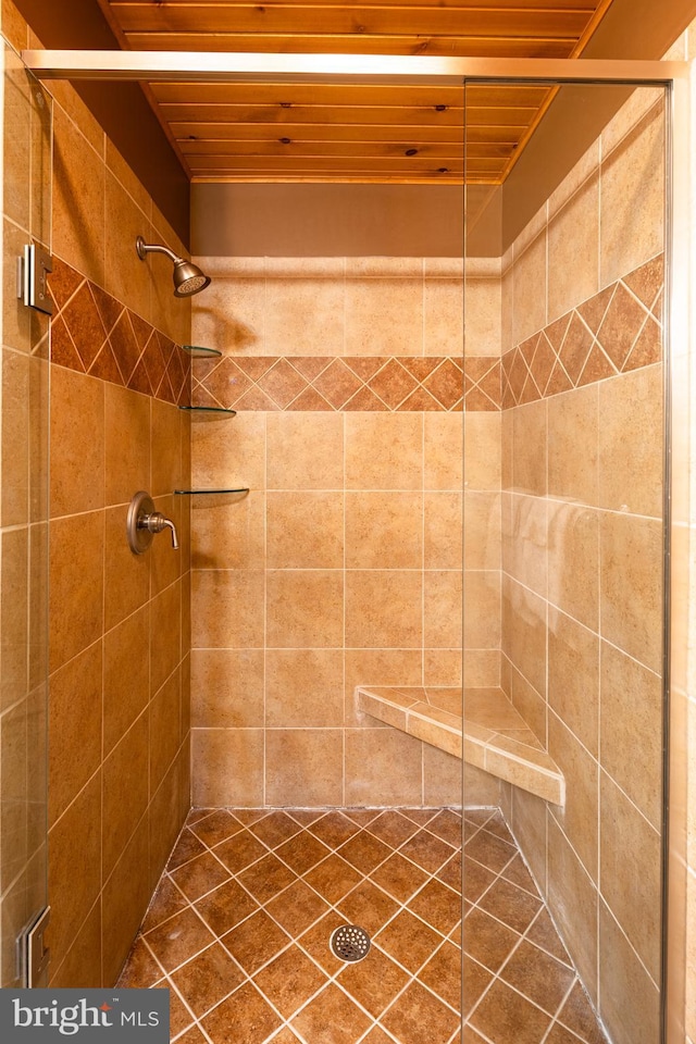 bathroom with wooden ceiling and tiled shower