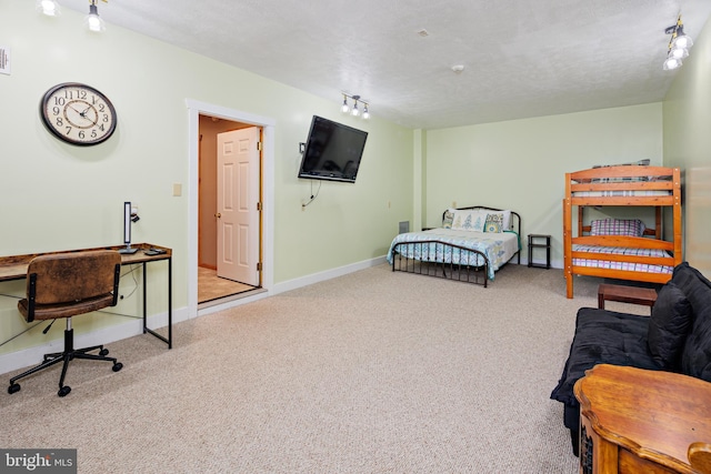 bedroom with light colored carpet, a textured ceiling, and rail lighting