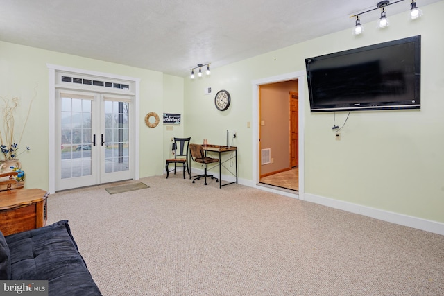 sitting room with french doors, light carpet, and rail lighting