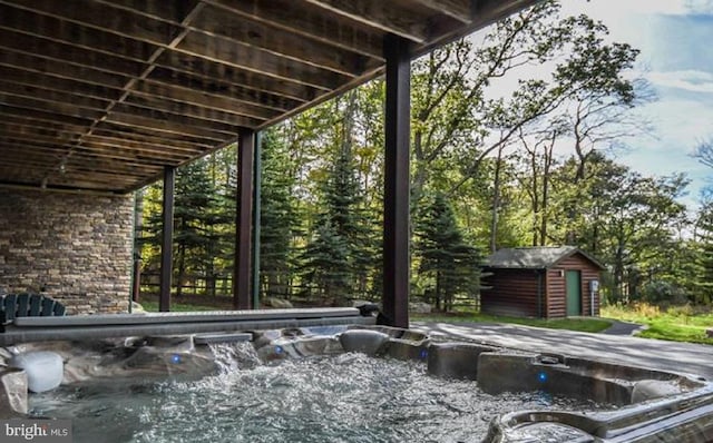 exterior space featuring a hot tub and a storage shed