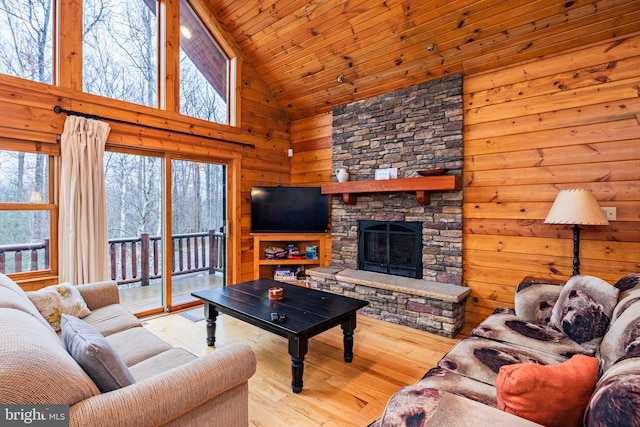 living room featuring wooden ceiling, a fireplace, light hardwood / wood-style flooring, and high vaulted ceiling