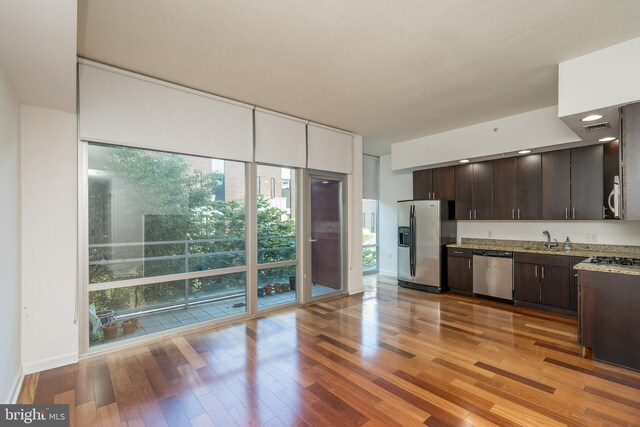 kitchen featuring a wealth of natural light, dark brown cabinets, light hardwood / wood-style floors, and stainless steel appliances