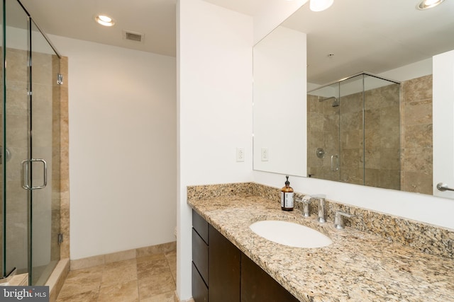 bathroom featuring a shower with shower door, tile flooring, and vanity