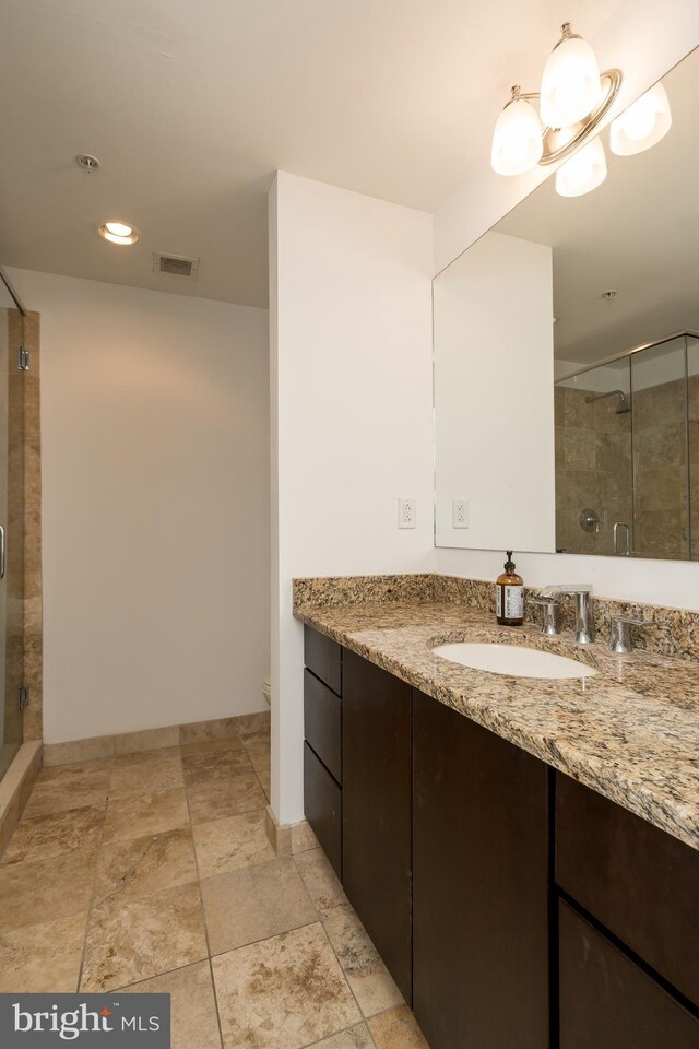 bathroom with oversized vanity, toilet, tile floors, and a shower with shower door