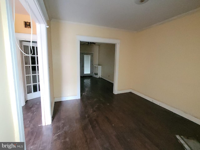 empty room with ceiling fan, dark wood-type flooring, and radiator