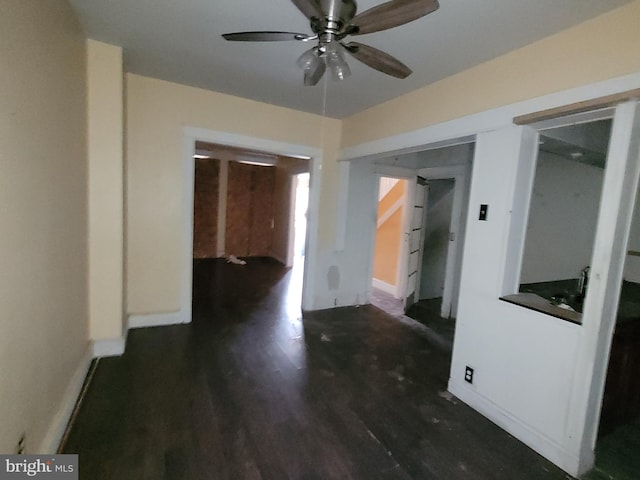 empty room with ceiling fan and dark hardwood / wood-style flooring