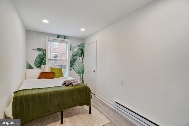 bedroom featuring a baseboard radiator and light hardwood / wood-style flooring