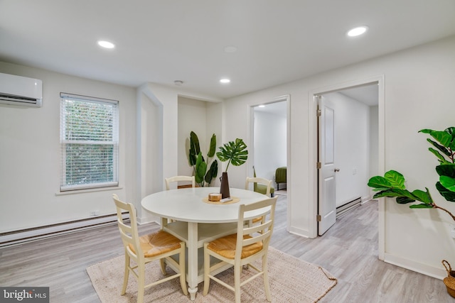 dining space featuring a baseboard radiator, light hardwood / wood-style floors, and a wall unit AC