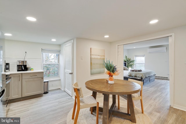 dining space with an AC wall unit, light hardwood / wood-style floors, and a baseboard radiator