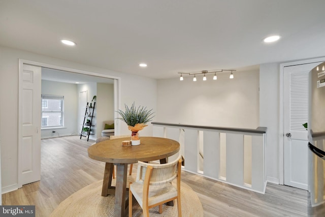 dining area featuring track lighting and light hardwood / wood-style floors