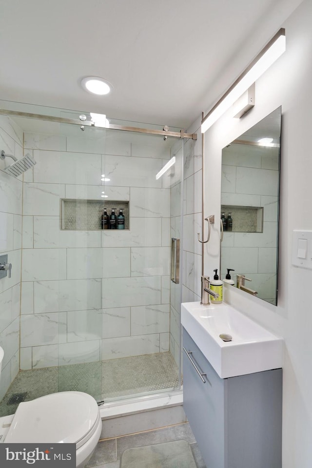 bathroom featuring an enclosed shower, toilet, tile floors, and vanity