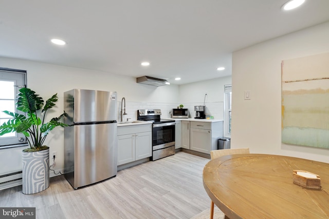 kitchen featuring tasteful backsplash, light hardwood / wood-style flooring, and appliances with stainless steel finishes