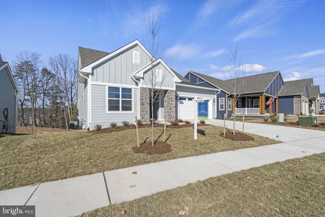 view of front of property featuring a front lawn, covered porch, and a garage