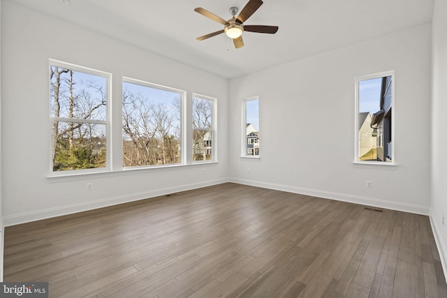 empty room with ceiling fan and dark hardwood / wood-style flooring