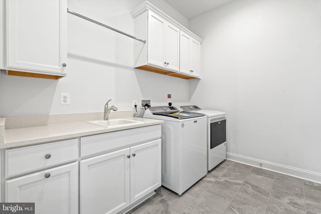 laundry area featuring washer and clothes dryer, sink, and cabinets