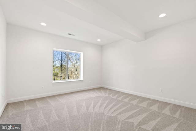 carpeted empty room featuring beam ceiling