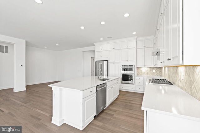 kitchen featuring white cabinets, appliances with stainless steel finishes, a center island with sink, and sink