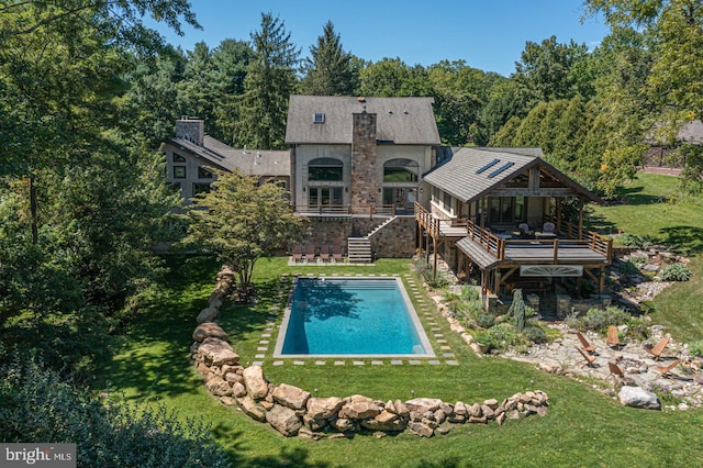 view of pool featuring a wooden deck and a lawn