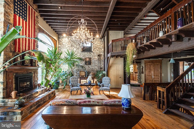 3111 Burnt House Hill Rd, Doylestown, PA 18902 - living room featuring wood-type flooring, a notable chandelier, beam ceiling, a towering ceiling, and a stone fireplace
