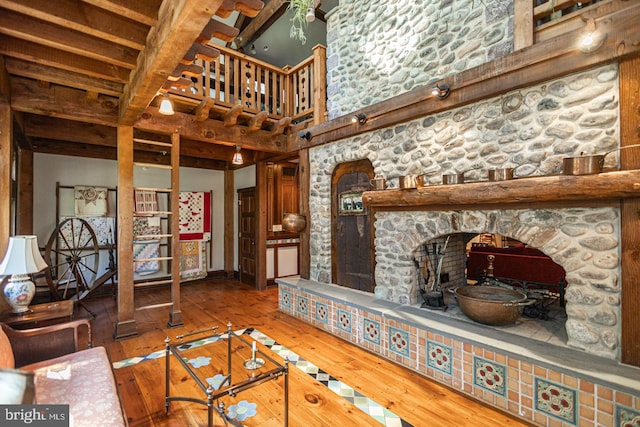 3111 Burnt House Hill Rd, Doylestown, PA 18902 - unfurnished living room featuring dark hardwood / wood-style flooring, beam ceiling, and a stone fireplace