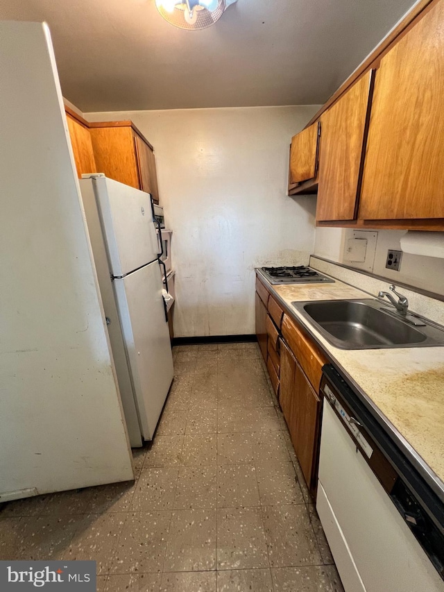 kitchen with stainless steel gas stovetop, dishwasher, white refrigerator, and sink