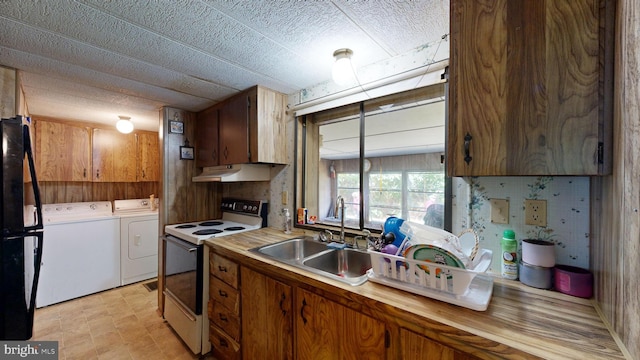 kitchen with separate washer and dryer, black refrigerator, sink, and white electric stove