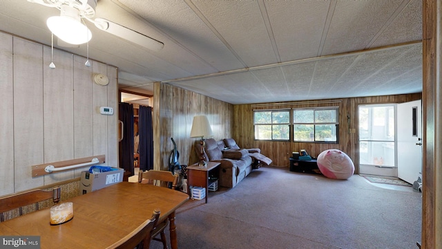 interior space with ceiling fan and wooden walls