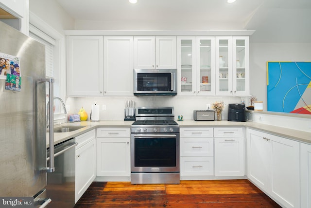 kitchen with sink, dark hardwood / wood-style flooring, white cabinets, stainless steel appliances, and tasteful backsplash