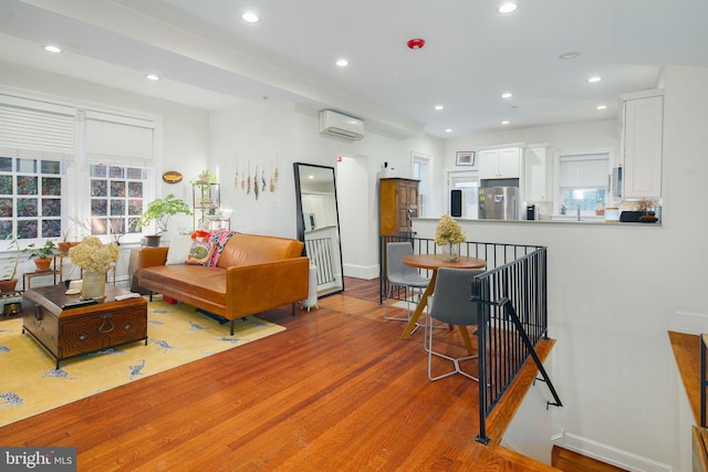 living room with an AC wall unit and wood-type flooring