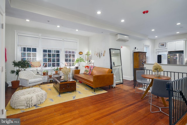 living room with a wall mounted AC and hardwood / wood-style flooring