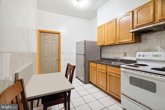 kitchen featuring white electric range, stainless steel fridge, light tile flooring, and sink